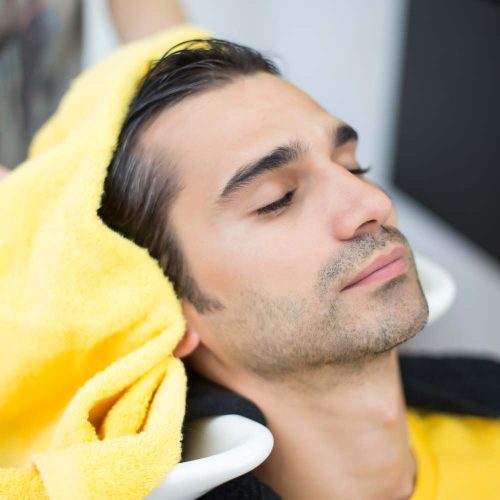 Man wordt gewassen bij de kapper